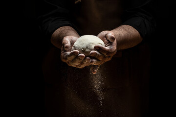 Obraz na płótnie Canvas Clap hands of baker with flour. Beautiful and strong men's hands knead the dough make bread, pasta or pizza. Powdery flour flying into air