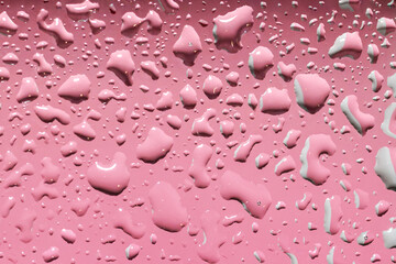 Pink gradient background with voluminous, different, shiny water drops. Abstract backdrop design