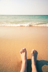 Woman legs sand beach and water sea. Vintage retro photo effect.