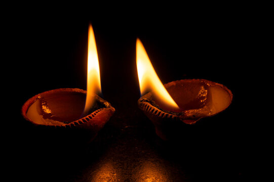 Side view of candles or diyas, Deepawali lights at night. Dark background stock image.