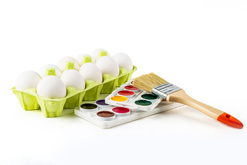 Egg cassette on a white background and a molar brush with watercolors. Humor for painting eggs for...