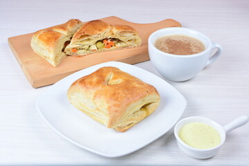 Puff pastry cake with vegetables and cheese, on wooden background