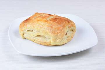 Puff pastry with meat, vegetables and cheese, on a wooden background
