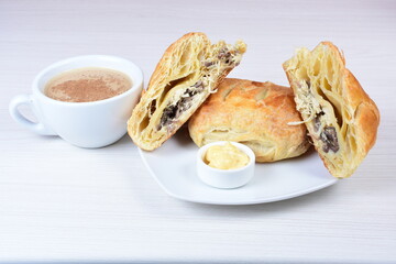Puff pastry with meat, vegetables and cheese, on a wooden background