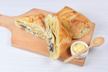 Puff pastry with meat, vegetables and cheese, on a wooden background