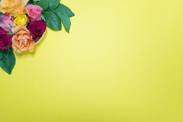 fond jaune avec roses de plusieurs couleurs au coin