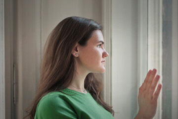portrait of young woman while looking out the window