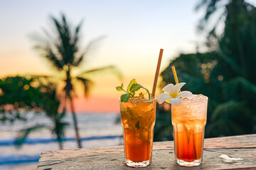 drinks with blur beach and sunset in background - obrazy, fototapety, plakaty