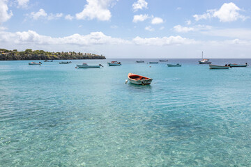 Small fishing boats on the crystal clear, turquoise waters at Playa Grandi (Playa Piscado) on the...