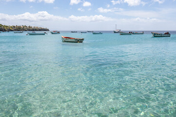 Small fishing boats on the crystal clear, turquoise waters at Playa Grandi (Playa Piscado) on the Caribbean island Curacao
