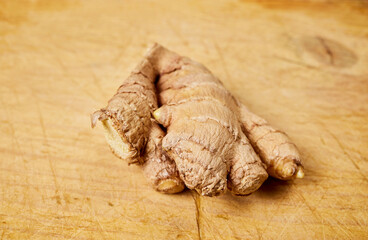 Ginger. Tuber piece on a wooden board