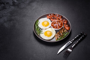 Full english breakfast with bean, fried eggs, roasted sausages, tomatoes and mushrooms