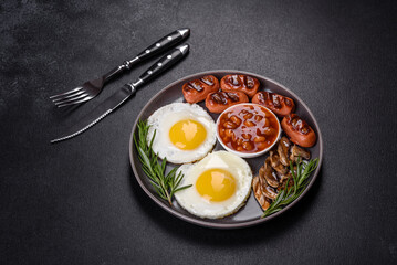 Full english breakfast with bean, fried eggs, roasted sausages, tomatoes and mushrooms