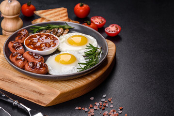 Full english breakfast with bean, fried eggs, roasted sausages, tomatoes and mushrooms