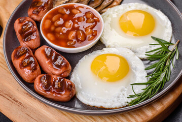 Full english breakfast with bean, fried eggs, roasted sausages, tomatoes and mushrooms