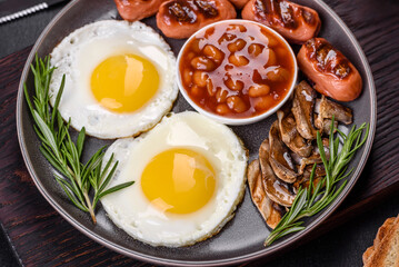 Full english breakfast with bean, fried eggs, roasted sausages, tomatoes and mushrooms