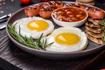 Full english breakfast with bean, fried eggs, roasted sausages, tomatoes and mushrooms