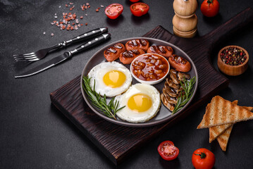 Full english breakfast with bean, fried eggs, roasted sausages, tomatoes and mushrooms