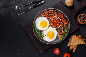 Full english breakfast with bean, fried eggs, roasted sausages, tomatoes and mushrooms