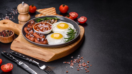 Full english breakfast with bean, fried eggs, roasted sausages, tomatoes and mushrooms
