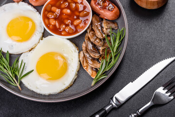 Full english breakfast with bean, fried eggs, roasted sausages, tomatoes and mushrooms