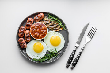 Full english breakfast with bean, fried eggs, roasted sausages, tomatoes and mushrooms