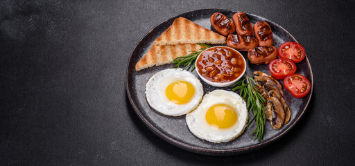 Full english breakfast with bean, fried eggs, roasted sausages, tomatoes and mushrooms