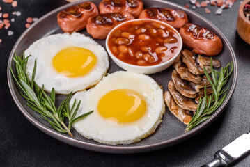 Full english breakfast with bean, fried eggs, roasted sausages, tomatoes and mushrooms