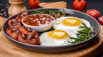 Full english breakfast with bean, fried eggs, roasted sausages, tomatoes and mushrooms