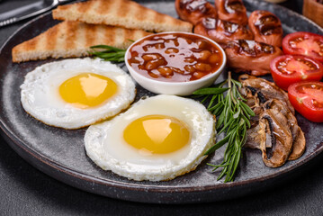 Full english breakfast with bean, fried eggs, roasted sausages, tomatoes and mushrooms