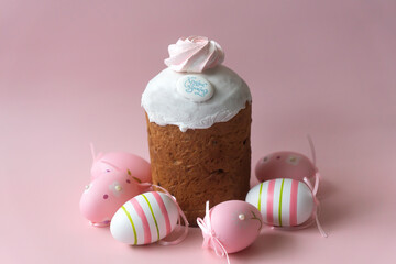 Easter cake with the inscription Christ is Risen, painted eggs and a willow branch on a pink...