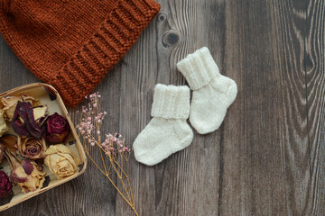 Fototapeta na wymiar Small woolen baby socks, on dark wooden background