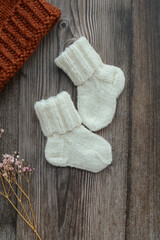 Fototapeta na wymiar Small woolen baby socks, on dark wooden background