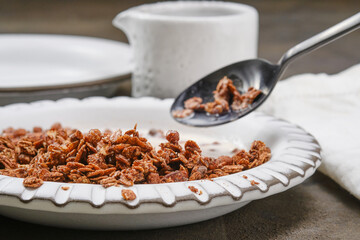 Bowl of muesli with milk and spoon. Healthy Breakfast. Chocolate granola in a bowl. Shallow depth of field