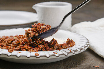 Bowl of muesli with milk and spoon. Healthy Breakfast. Chocolate granola in a bowl. Shallow depth of field