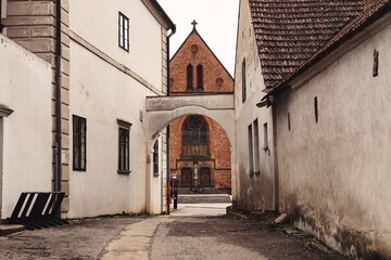 Fototapeta na wymiar A passage between the historical houses with view to the church at Uhercice, Czech republic