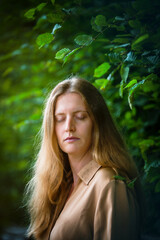 Fototapeta premium portrait of blond woman in nature with her eyes closed