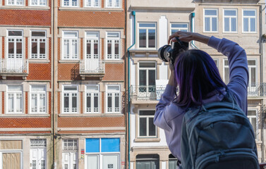 View from behind Traveller Woman take a photo of Colorful houses of Porto, traditional facades