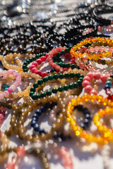 Background of Many bracelets made of various natural multicolored stones. Selective focus