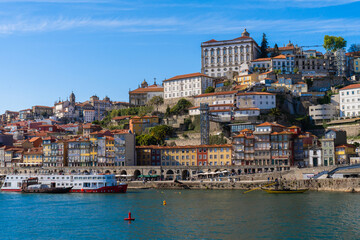 Naklejka na ściany i meble Cityscape of the city of Porto, Douro river with its old boat and its typical colored houses on the water's edge. Portugal. Europe.