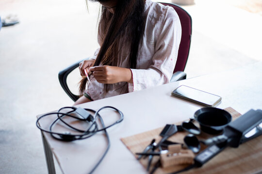 Damaged Hair, frustrated asian young woman, girl hand in holding brush splitting ends messy while combing hair, unbrushed dry long hair. Health care beauty concept.