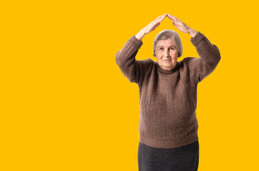 Roof over your head and own home concept with old age woman holding her hands under her head.