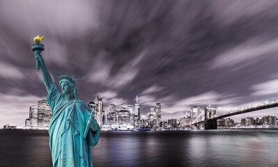 Fototapeta premium Manhattan panoramic skyline at night. New York City, USA. Statue of Liberty National Monument with skyscrapers background.