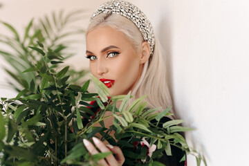 Fototapeta premium Portrait of a beautiful girl of Slavic appearance next to a green flower.