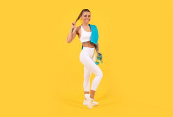 Fototapeta na wymiar happy sport woman with water bottle on yellow background