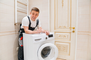 a man repairs a washing machine. repairman