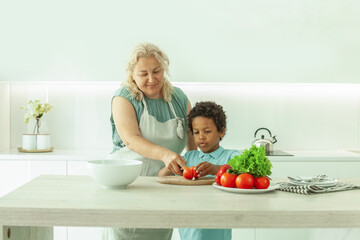 Happy family with little child preparing salad together