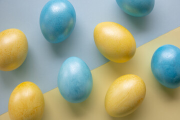 Easter yellow and blue eggs on a paper background. Flat lay, top view