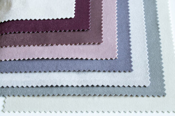 A palette of velor soft fabric in different colors for furniture upholstery as a background close up, fashion fabric for backdrops