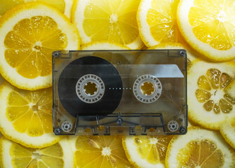 Top view of frame made from yellow slices of lemons with vintage audio cassette. retro music...